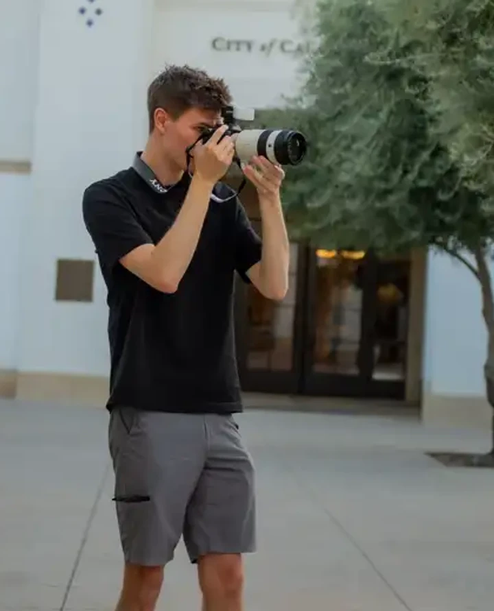 Matt photographing outside with a camera.