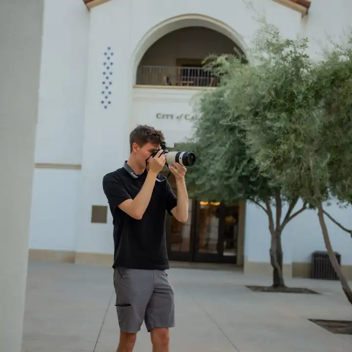 Matt photographing outside with a camera.